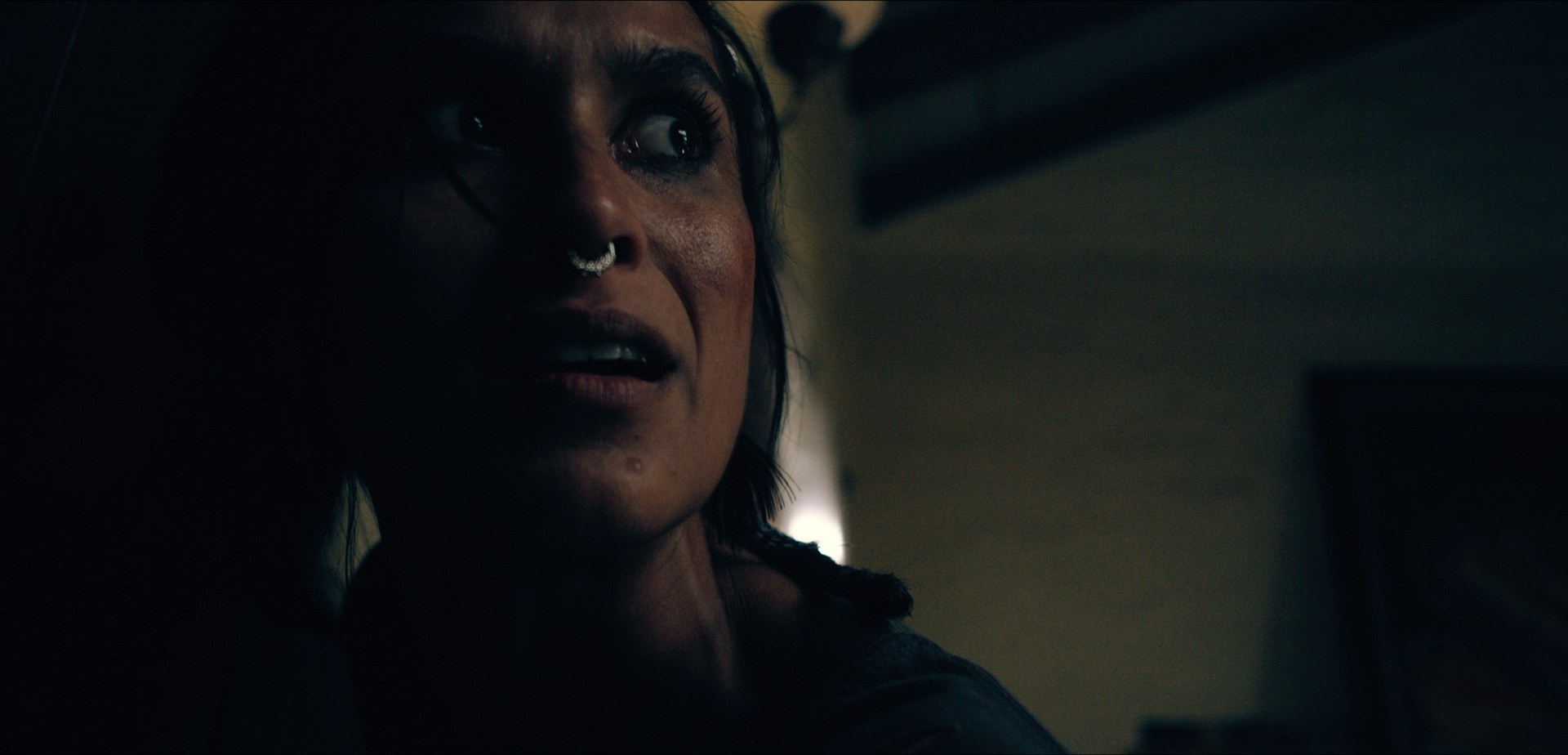 A woman looking upward in a dark room
